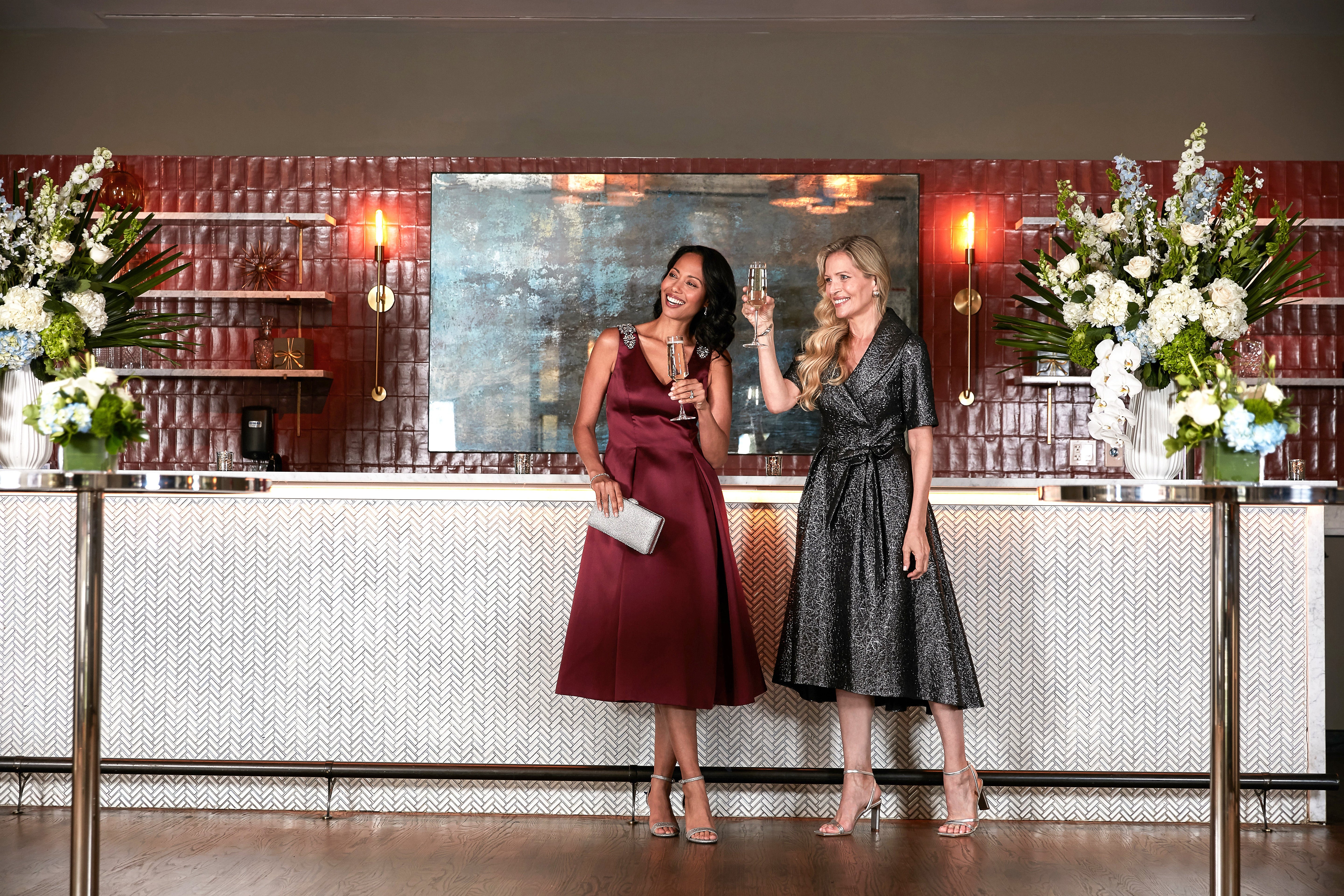 two women in red and charcoal dresses