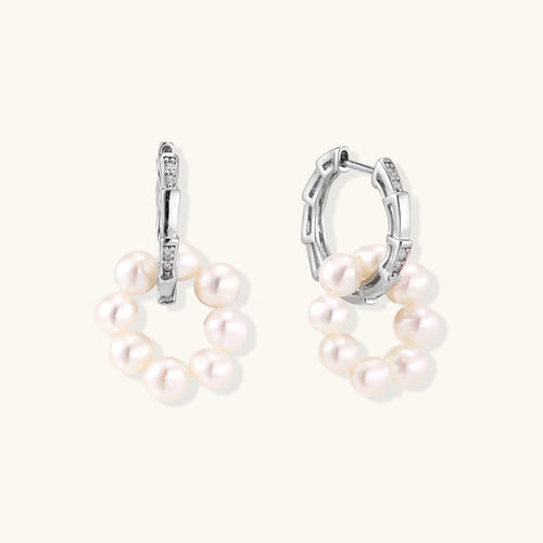 Sterling silver huggie hoop earrings with clustered white freshwater pearls and crystal accents on white background.
