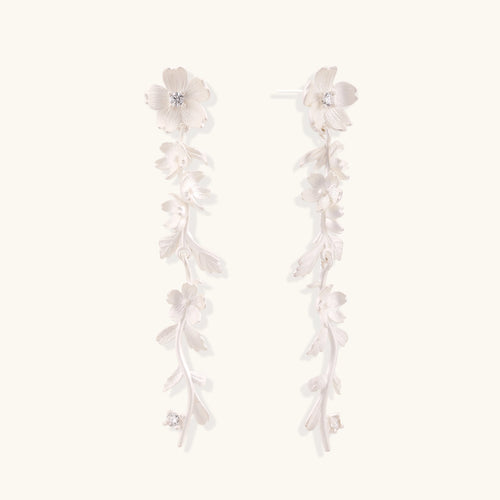 Pair of sterling silver dangle earrings with intricate leaf vine patterns and crystal accents on white background.