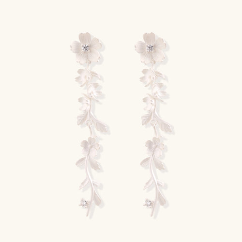 Pair of sterling silver dangle earrings with intricate leaf vine patterns and crystal accents on white background.