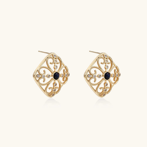 Ornate 18K gold plated stud earrings with intricate filigree design and central lapis lazuli stones on cream background.