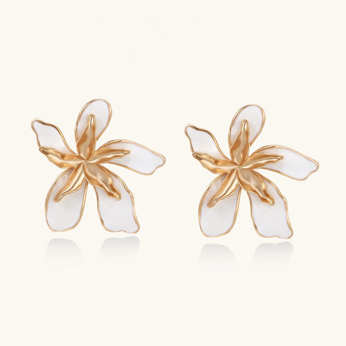 Large floral stud earrings with gold-plated brass petals and white enamel centers on neutral background