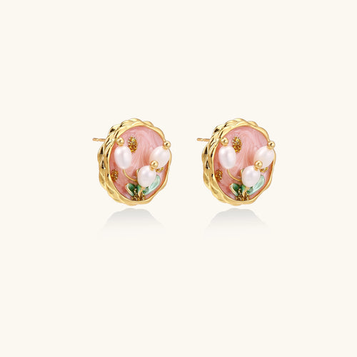 Round stud earrings with pink enamel background, white pearl tulips, green leaves, and twisted gold border on white background.