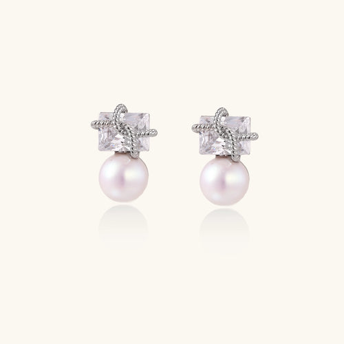 Gold-plated stud earrings with square crystal tops wrapped in twisted wire and freshwater pearl drops on white background