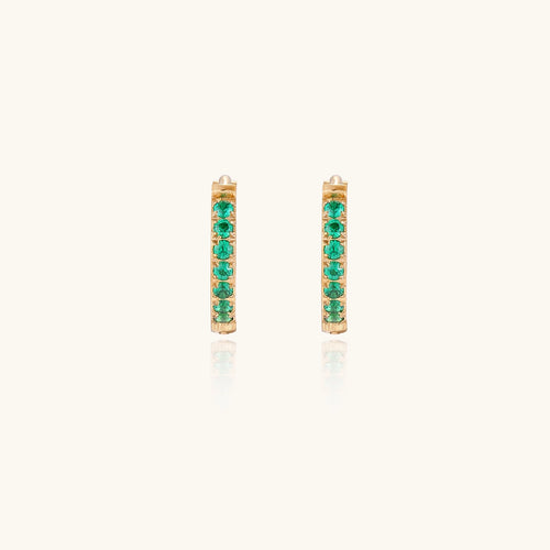 Small gold-plated huggie hoop earrings with emerald green cubic zirconia stones, one open showing hinge mechanism